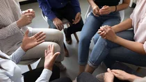 Teilnehmerinnen und Teilnehmer einer Selbsthilfegruppe sitzen im Stuhlkreis.