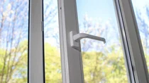 Ein Fenster steht offen. Im Hintergrund sind B&auml;ume und ein blauer Himmel zu sehen.