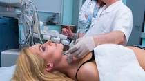 Arzt untersucht Schilddrüse per Ultraschall.