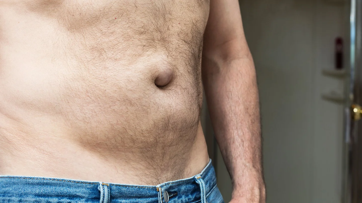 Hernien (Leistenbruch): Ein Mann zeigt seinen freien Oberk&ouml;rper und Bauch.