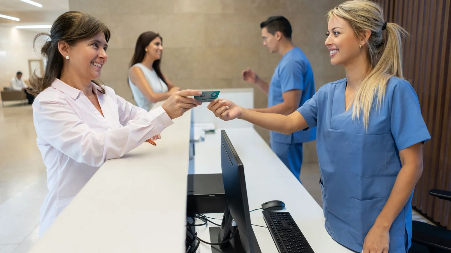 Elektronische Gesundheitskarte: Eine Patientin reicht der Sprechstundenhilfe ihre elektronische Gesundheitskarte.