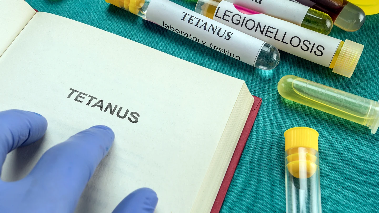 Buch und Teströhrchen mit der Aufschrift Tetanus.