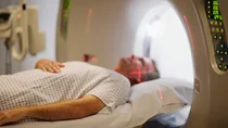 Multiples Myelom: Ein Mann liegt in einer MRT-R&ouml;hre. &Uuml;ber seinem Gesicht verlaufen zwei rote Laser.