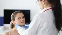 &Auml;rztin tastet die Bereiche der Unterkieferspeicheldr&uuml;se einer Patientin ab.