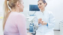 Eine Frau spricht im Behandlungszimmer mit ihrer Frauenärztin.