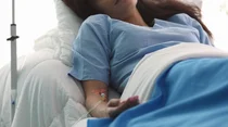 Frau mit Infusion im Krankenbett