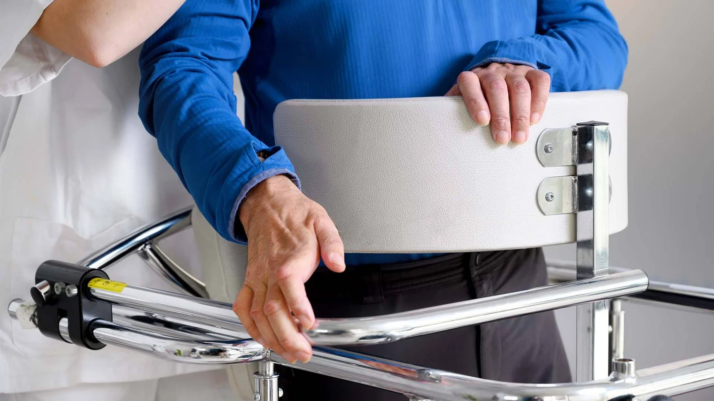 Person mit Gehilfe, unterstützt von einer medizinischen Fachkraft.