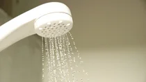 Ein Duschkopf mit fallenden Wassertropfen.