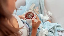 Erkältung: Eine Frau hält eine Tasse Tee in der Hand.