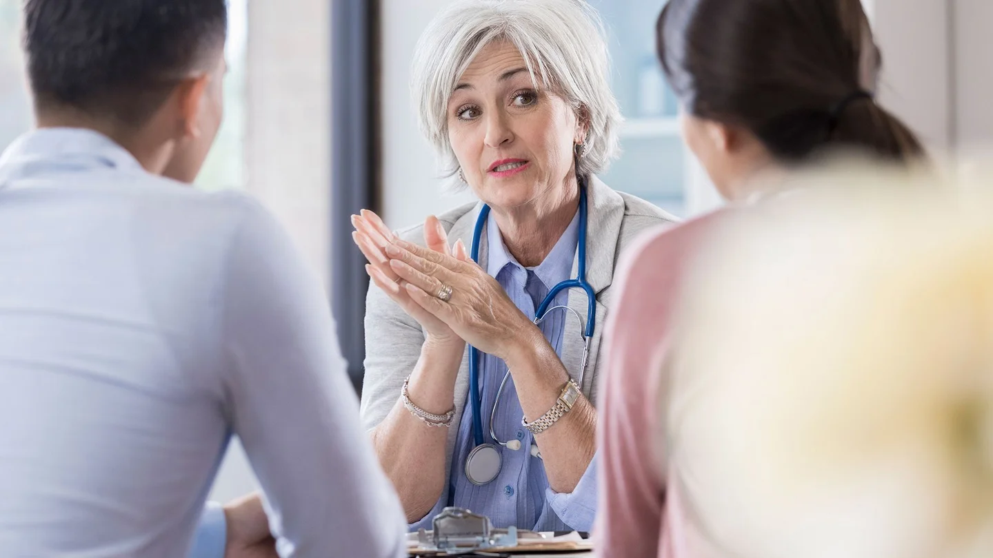 Eine Ärztin redet mit einem Paar.