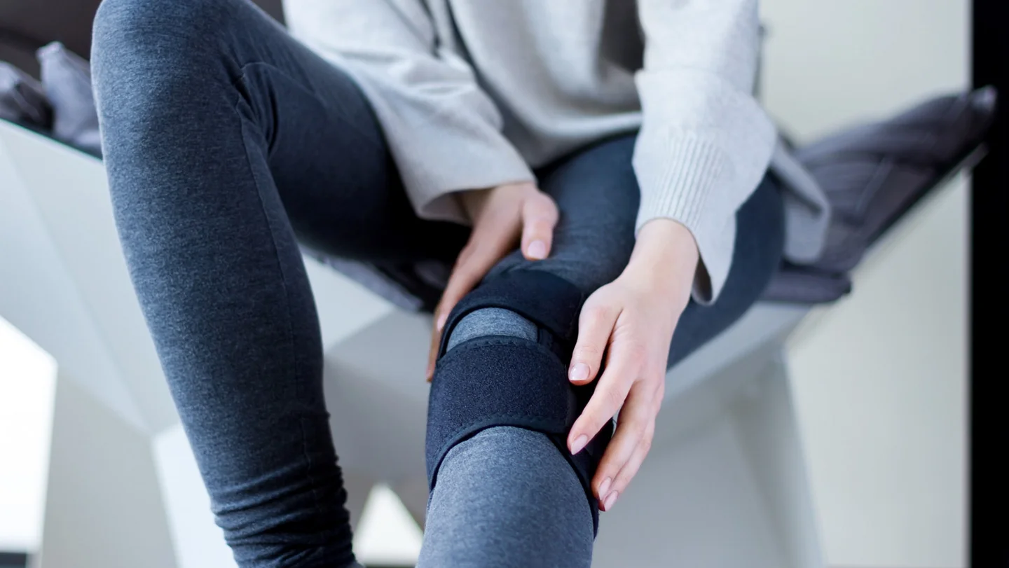 Frau mit einer Bandage am Knie