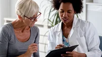 Eine Ärztin erklärt einer Patientin etwas und zeigt dabei auf ihre Unterlagen. 
