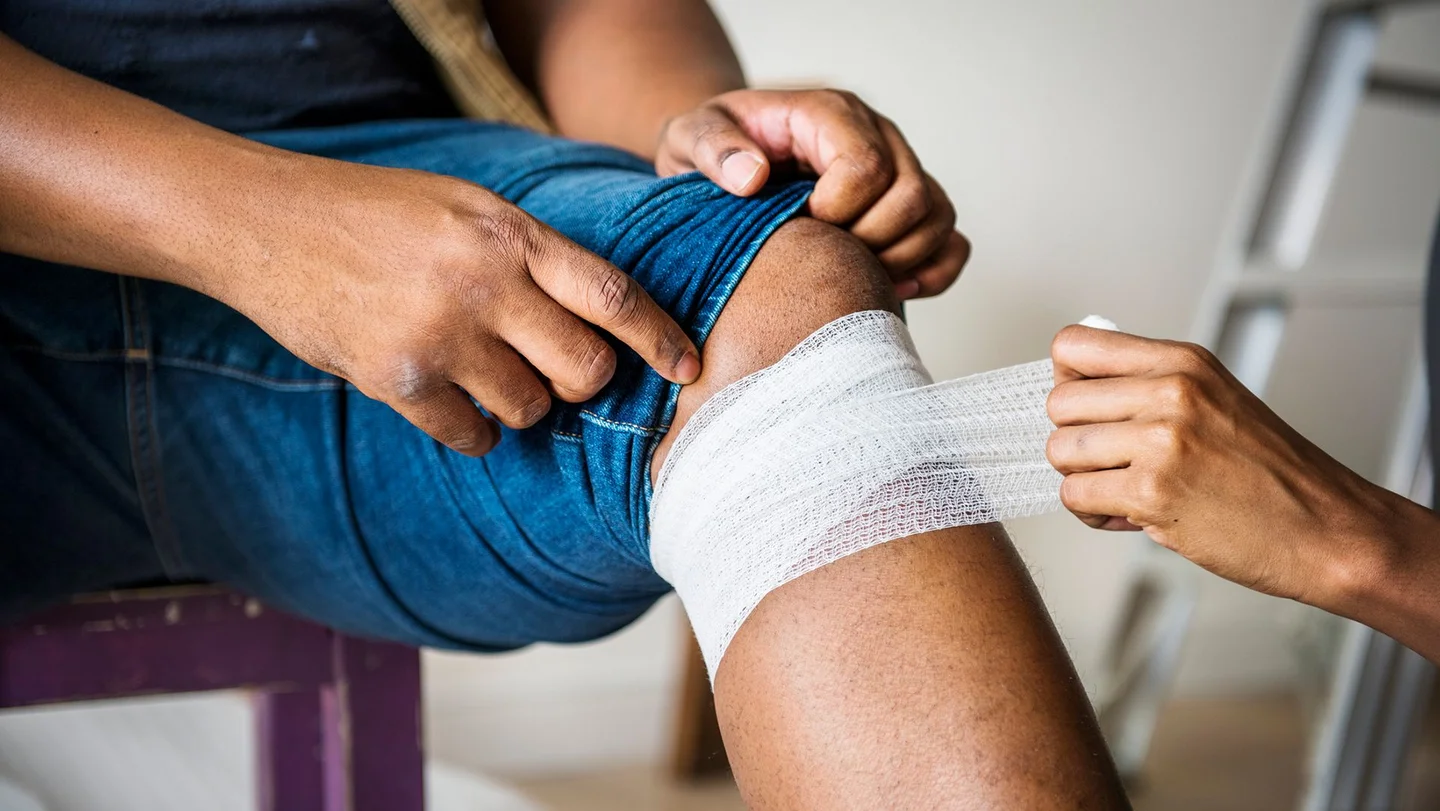 Anlegen eines Wundverbands unterhalb des Knies