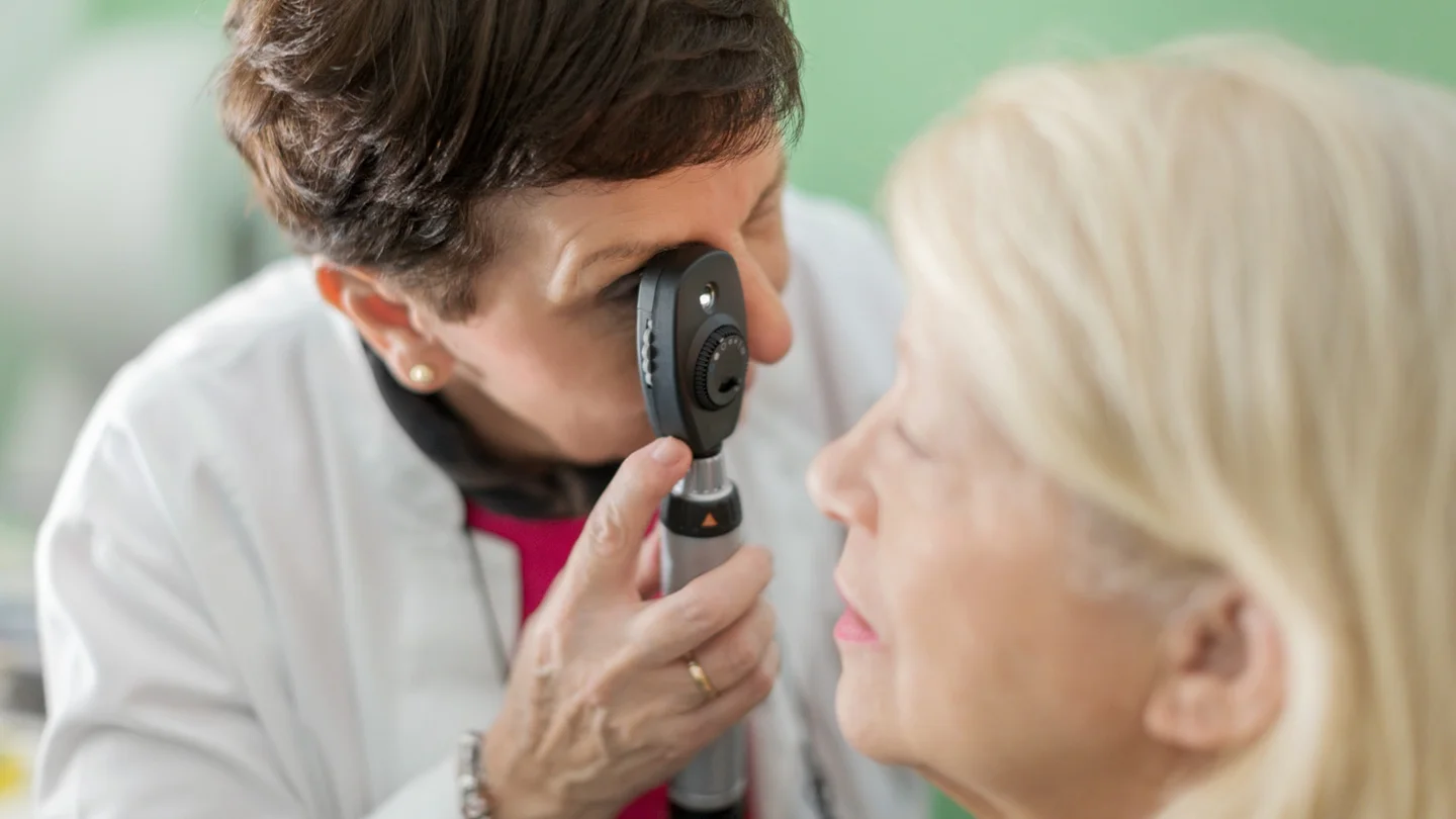 Glaukom: Eine &Auml;rztin schaut durch ein Skiaskop in das Auge einer Patientin.