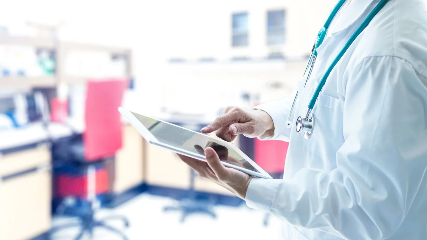 Ein Arzt &ouml;ffnet auf einem Tablet eine elektronische Patientenakte.